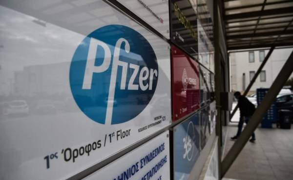 A man entry at the building where Pfizer's office located in Thessaloniki on November 10, 2020. - Pfizer stock surged higher on November 9, 2020 prior to the opening of Wall Street trading after the company announced its vaccine is '90 percent effective' against Covid-19 infections. The news cheered markets worldwide, especially as coronavirus cases are spiking, forcing millions of people back into lockdown. (Photo by Sakis MITROLIDIS / AFP)