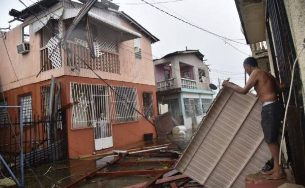 Residentes de San Juan, Puerto Rico, recuperan algo de entre los escombros de sus viviendas afectadas por el huracán María. El ciclón abatió a la isla con vientos de 240km/h. AFP PHOTO / Hector RETAMAL