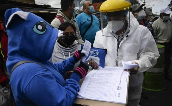 A health worker delivers medicines to patients who tested positive for a Covid-19 test at a mobile laboratory, during a spike in the number of positive coronavirus cases, in Guatemala City, August 25, 2021. - (Photo by Johan ORDONEZ / AFP)