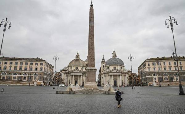 Una persona con máscara respiratoria cruza una desierta Piazza del Popolo en el centro de Roma, Italia. Foto Andreas SOLARO / AFP