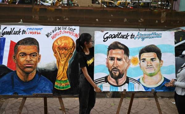 Students adjust paintings of Argentina's forward Lionel Messi and France's forward Kylian Mbappé ahead of the Qatar 2022 FIFA World Cup football final match between France and Argentina, at an art school in Mumbai on December 16, 2022. (Photo by Punit PARANJPE / AFP)