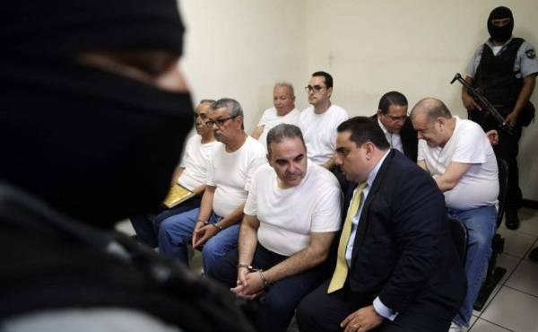 Former Salvadoran President (2004-2009) Elias Antonio Saca (C) talks with his lawyer as he waits to hear his sentence alonside five of his collaborators at a courtroom in San Salvador on September 12, 2018.Saca was sentenced to ten years in jain for the diversion of 301 million dollars during his term of office. / AFP PHOTO / MARVIN RECINOS