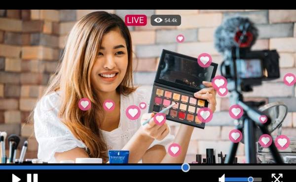 Young beautiful woman recording live stream video for makeup and cosmetics business purpose online with video player interface and full of positive feedbacks