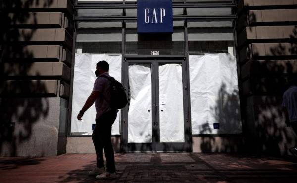 SAN FRANCISCO, CALIFORNIA - AUGUST 18: A pedestrian walks by the closed GAP flagship store on August 18, 2020 in San Francisco, California. Gap Inc. announced that they will permanently close its flagship store in San Francisco and all but one store in the city due to a drop in retail sales as the coronavirus COVID-19 pandemic continues. Justin Sullivan/Getty Images/AFP