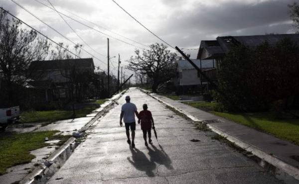 Una pareja camina en Montegut, Louisiana tras el paso del huracán Ida. Al menos dos personas han muerto tras el derrumbe de una de las principales autopistas que unen Luisiana y Misisipi, los dos Estados más golpeados por las tormentas que ha descargado el huracán Ida (Photo by Mark Felix / AFP)