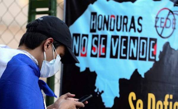 Cientos de pobladores procedentes de diferentes zonas de Honduras protestaron este viernes contra la instalación en sus comunidades de las llamadas 'ciudades modelo', unos espacios autónomos de los que, según dicen, serán expulsados. (Photo by Orlando SIERRA / AFP)
