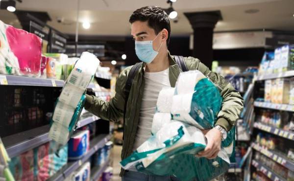 Young Man shopping in a supermarket, breathing through a medical mask because of the danger of getting the flu virus, influenza infection. Corona virus pandemic concept. Covid-19 virus!
