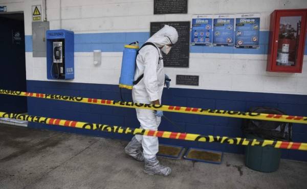 A health worker wearing a protective suit disinfects sports dorms used to house Guatemalan citizens who are deported from the U.S. in Guatemala City on May 14, 2020. (Photo by Johan ORDONEZ / AFP)