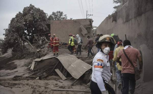Rescuers search for victims in San Miguel Los Lotes, a village in Escuintla Department, about 35 km southwest of Guatemala City, on June 4, 2018, a day after the eruption of the Fuego VolcanoAt least 25 people were killed, according to the National Coordinator for Disaster Reduction (Conred), when Guatemala's Fuego volcano erupted Sunday, belching ash and rock and forcing the airport to close. / AFP PHOTO / Johan ORDONEZ