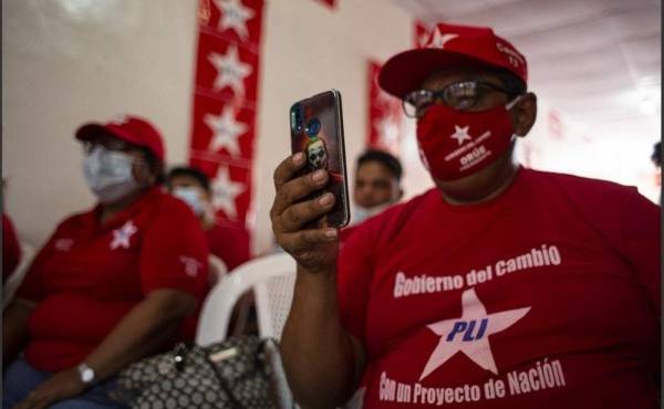 A supporter of Nicaragua's Liberal Independent Party (PLI) presidential candidate Mauricio Orue Vazquez takes a snapshot with his mobile phone during the final campaign rally in Managua, on November 1, 2021. - Nicaragua will hold general election next November 7. (Photo by Oswaldo Rivas / AFP)