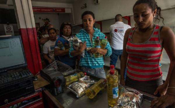 Una fila para comprar bienes escasos, como aceite y leche en polvo, en una tienda del gobierno en Puerto Cabello, Venezuela. (Foto: Meridith Kohut / The New York Times).