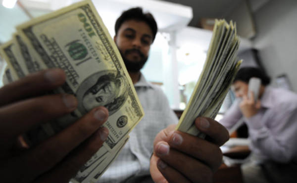 TO GO WITH 'Pakistan-UAE-Gulf-economy-remittances,FOCUS' by Hasan MansoorA Pakistani money dealer counts US dollars notes at a money market in Islamabad on April 20, 2009. Pakistani expatriate workers wired home a record 739.4 million dollars last month, but experts warn job losses abroad and the global credit crunch could soon slash remittances and haunt the economy. The March remittances from Pakistanis working overseas surpassed the previous monthly record of 673.5 million dollars last December. AFP PHOTO / Aamir QURESHI (Photo credit should read AAMIR QURESHI/AFP/Getty Images)