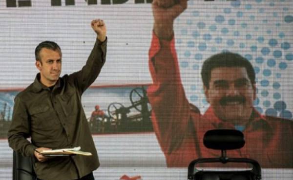 Venezuelan President Nicolas Maduro (not framed) and his vice-president Tareck El Aissami (L) participate in a rally with workers of PDVSA state-owned oil company in Carcas January 31, 2017. Maduro broadened the powers of his hardline number two in a decree Tuesday that analysts said showed he may be grooming him to take over as president. / AFP PHOTO / JUAN BARRETO