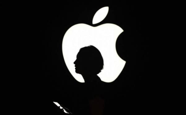 (FILES) In this file photo a reporter walks by an Apple logo during a media event in San Francisco, California on September 9, 2015. \ - Apple on August 19, 2020 became the first US company to reach $2 trillion in market value in the latest demonstration of how tech giants have benefited amid the upheaval of the coronavirus. The iPhone maker attained the distinction in mid-morning trading and was up 1.3 percent at $468.34 near 1500 GMT. In March 2018, Apple became the first giant to hit $1 trillion in market value. (Photo by Josh Edelson / AFP)