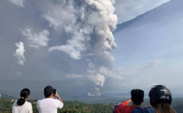 People take photos of a phreatic explosion from the Taal volcano as seen from the town of Tagaytay in Cavite province, southwest of Manila, on January 12, 2020. (Photo by Bullit MARQUEZ / AFP)