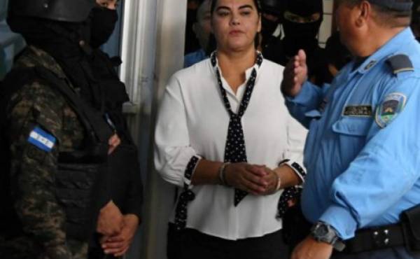 The wife of Honduran former president (2010-2014) Porfirio Lobo, Rosa Elena de Lobo -accused of misappropriation of public funds, illicit association and money laundering- is escorted upon arrival at a corruption court in Tegucigalpa on March 2, 2018. / AFP PHOTO / ORLANDO SIERRA