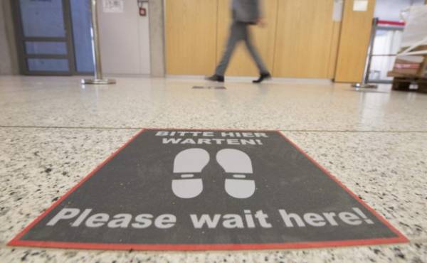 A signreading 'PLease wait here!' is fixed on the floor of the corona vaccination center at the Robert Bosch hospital in Stuttgart, southern Germany, on December 10, 2020, amid the new coronavirus COVID-19 pandemic. - The vaccination center is currently under construction and will have a capacity of 1500 vaccinations per day when it starts. (Photo by THOMAS KIENZLE / AFP)
