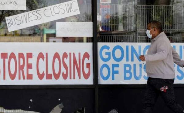 FILE - In this May 21, 2020 file photo, a man looks at signs of a closed store due to COVID-19 in Niles, Ill. U.S. businesses shed 2.76 million jobs in May, as the economic damage from the historically unrivaled coronavirus outbreak stretched into a third month. The payroll company ADP reported Wednesday that businesses have let go of a combined 22.6 million jobs since March.AP Photo/Nam Y. Huh, File)