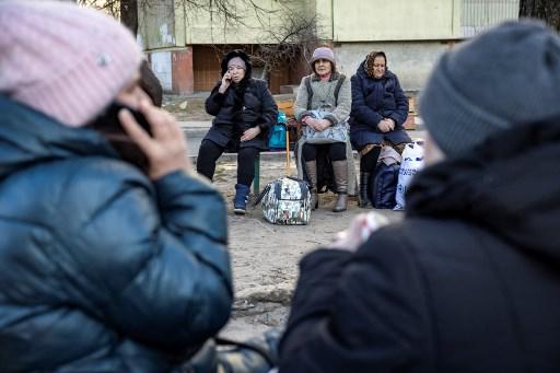 Residentes esperan en un parque después que un edificio residencial fue afectado tras ataque de un misil en Kiev el 20 de marzo de 2022. (Photo by FADEL SENNA / AFP)