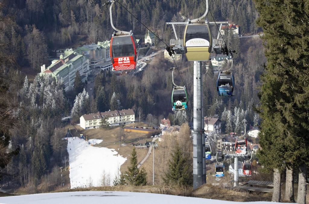 <i>Las cabañas de un telesilla se muestran con el pueblo de Semmering al fondo y la pista de práctica de la escuela de esquí Semmering en el complejo de deportes de invierno Zauberberg im Semmering, Baja Austria el 8 de enero de 2023. (Foto de Alex HALADA / AFP)</i>