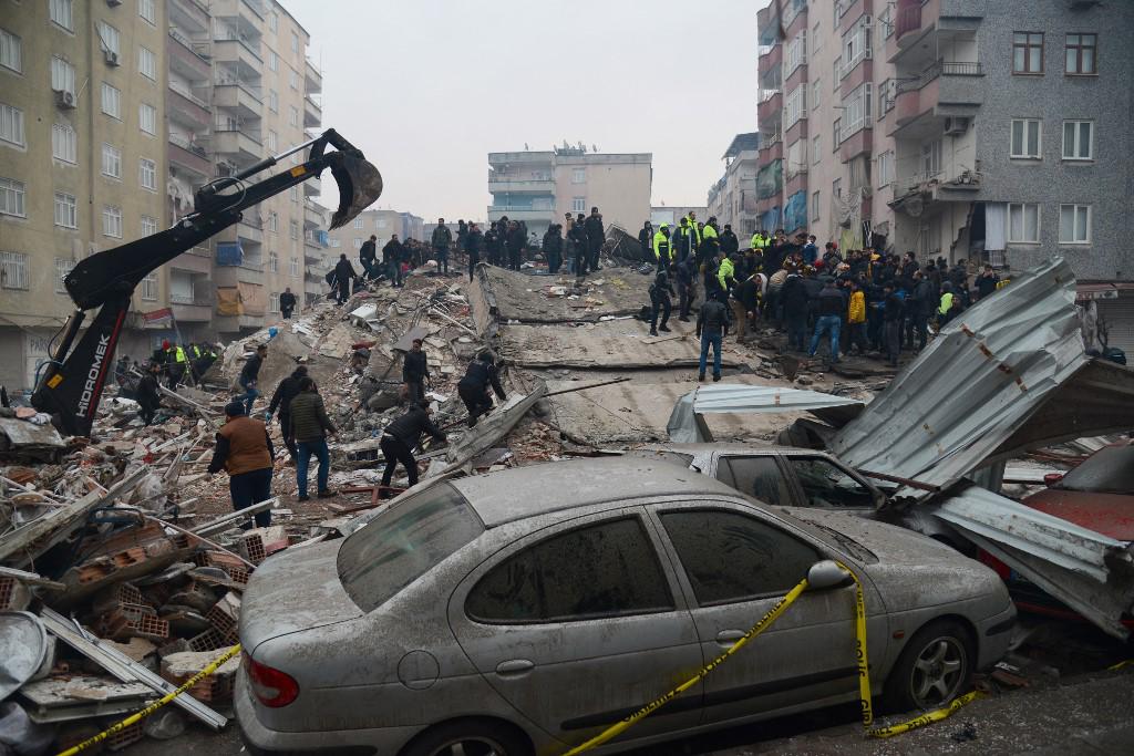 <i>La gente busca sobrevivientes en Diyarbakir, el 6 de febrero de 2023, después de que un terremoto de magnitud 7,8 azotara el sureste del país. - Al menos 284 personas murieron en Turquía y más de 2300 personas resultaron heridas en uno de los terremotos más grandes de Turquía en al menos un siglo, mientras continúan los trabajos de búsqueda y rescate en varias ciudades importantes. (Foto de ILYAS AKENGIN / AFP)</i>